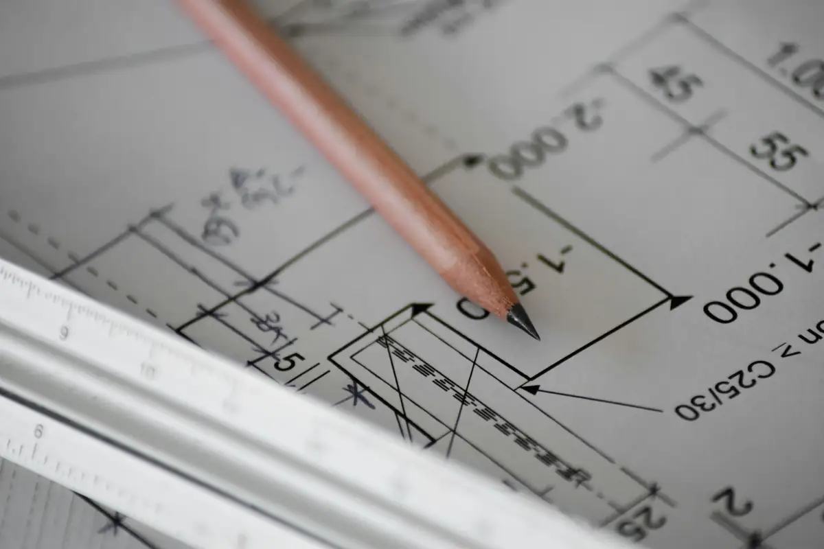 Pencil resting on an architectural drawing with measurements