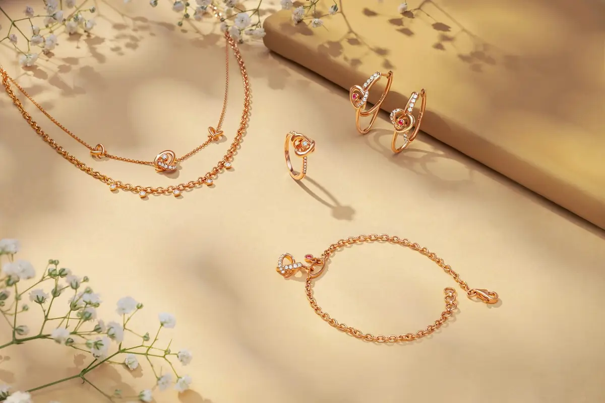 Gold rings, a bracelet and necklaces laid out on a cream surface
