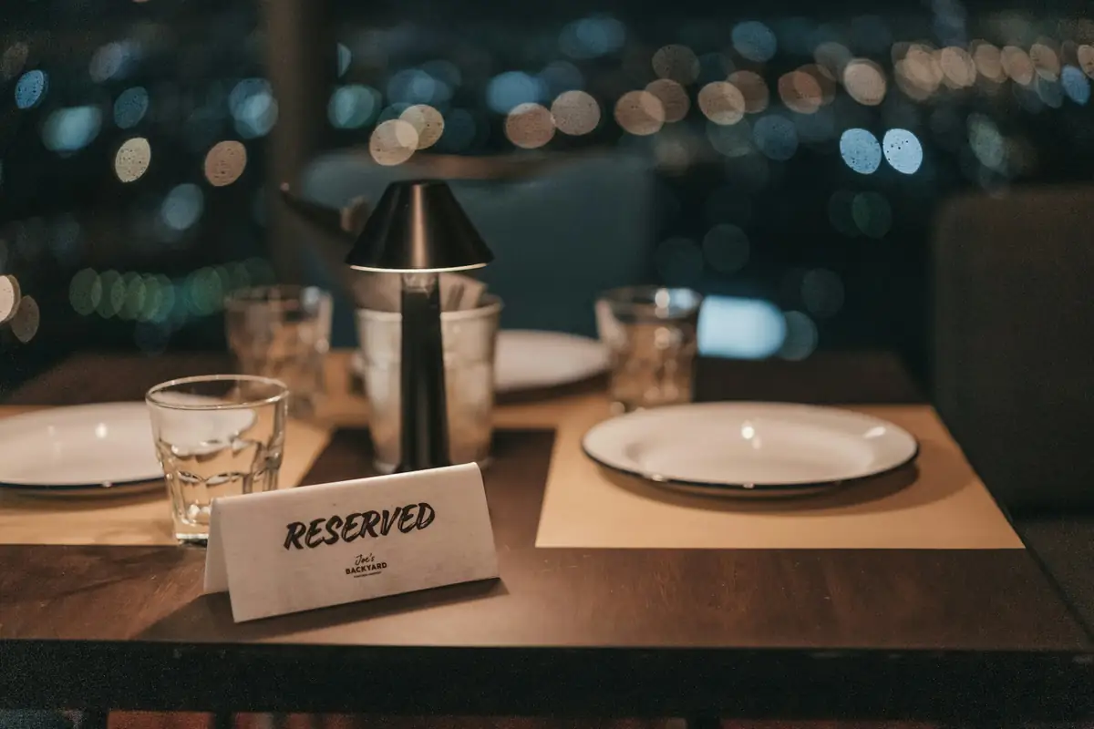 Restaurant table set with plates and glasses and a reserved sign