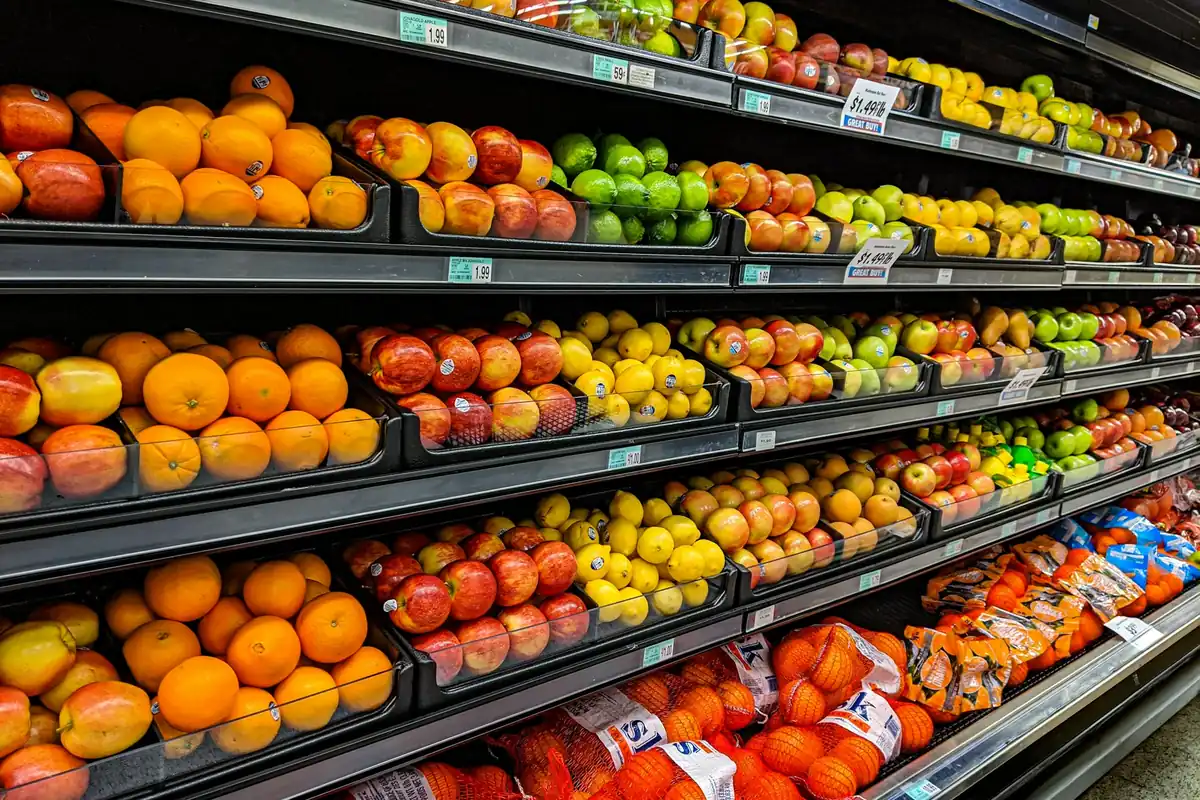Shelves of fruit and packaged goods in a grocery store aisle