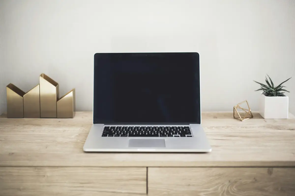Laptop on a wooden desk with small decorative objects